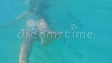 美丽的女孩在比基尼游泳<strong>水下</strong>和移动脚在镜头前。 去专业<strong>高清</strong>慢动作。